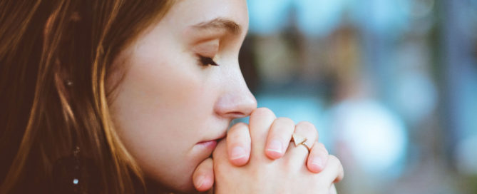 Woman praying that she can stop suffering and learn from COVID-19.